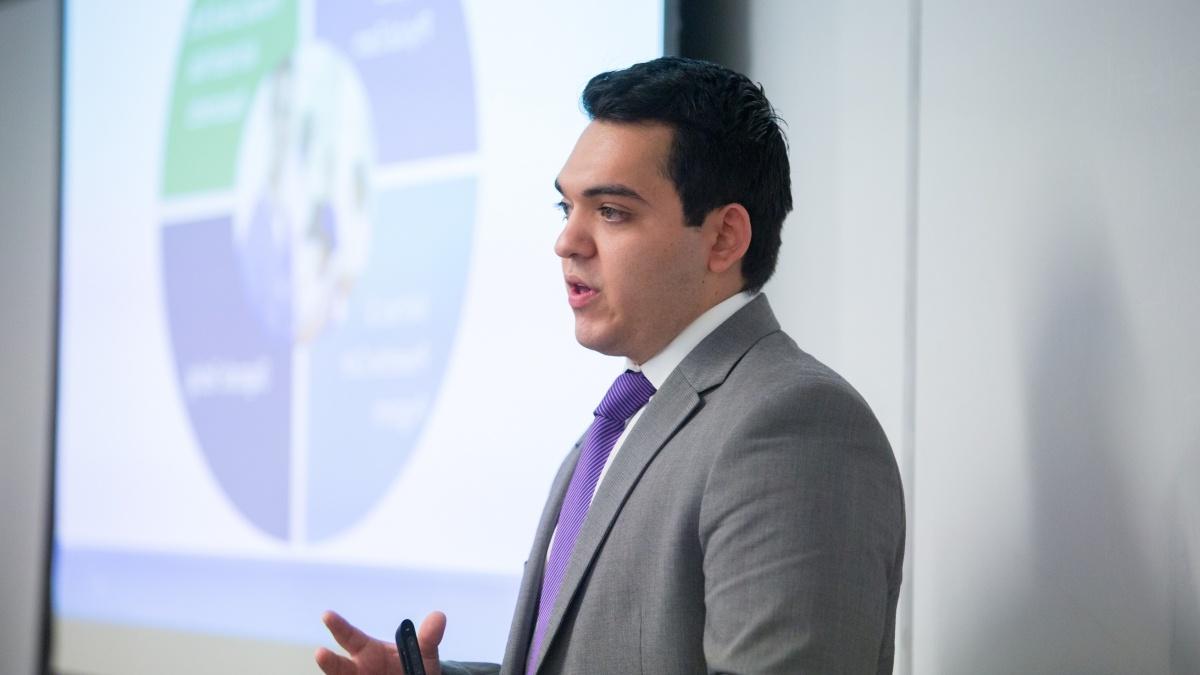 Graduate student presents a business plan in a classroom.